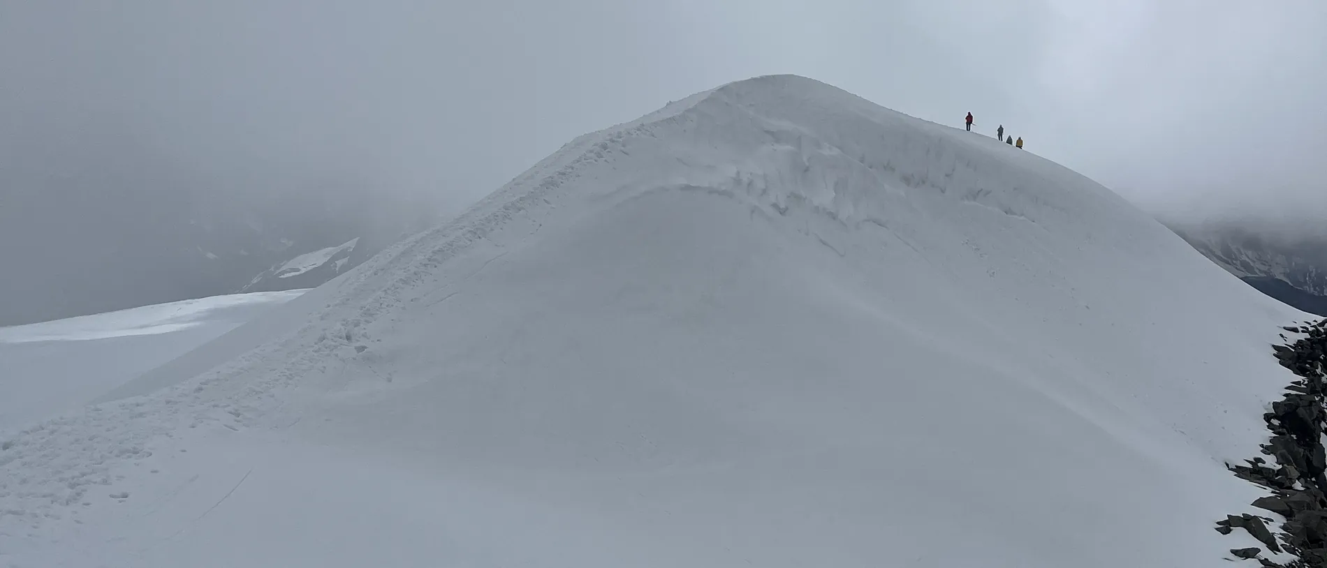 Seilschaft auf einem Firngrat im Nebel